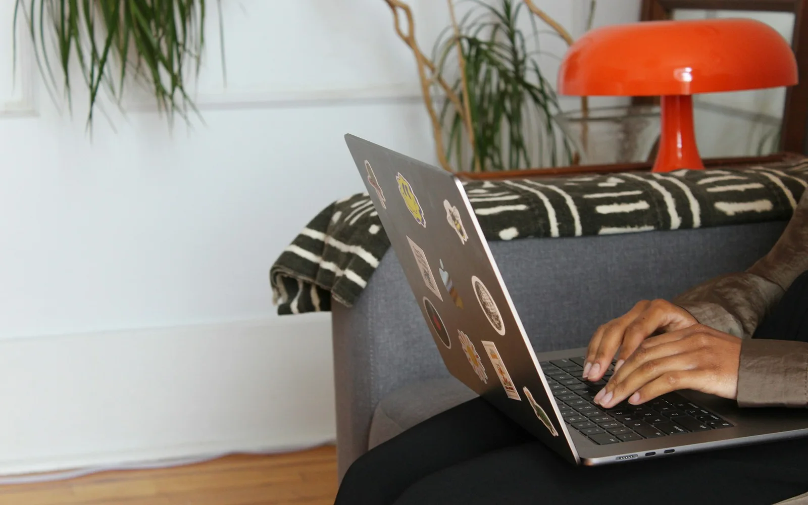 A woman uses a laptop while sitting comfortably at home.