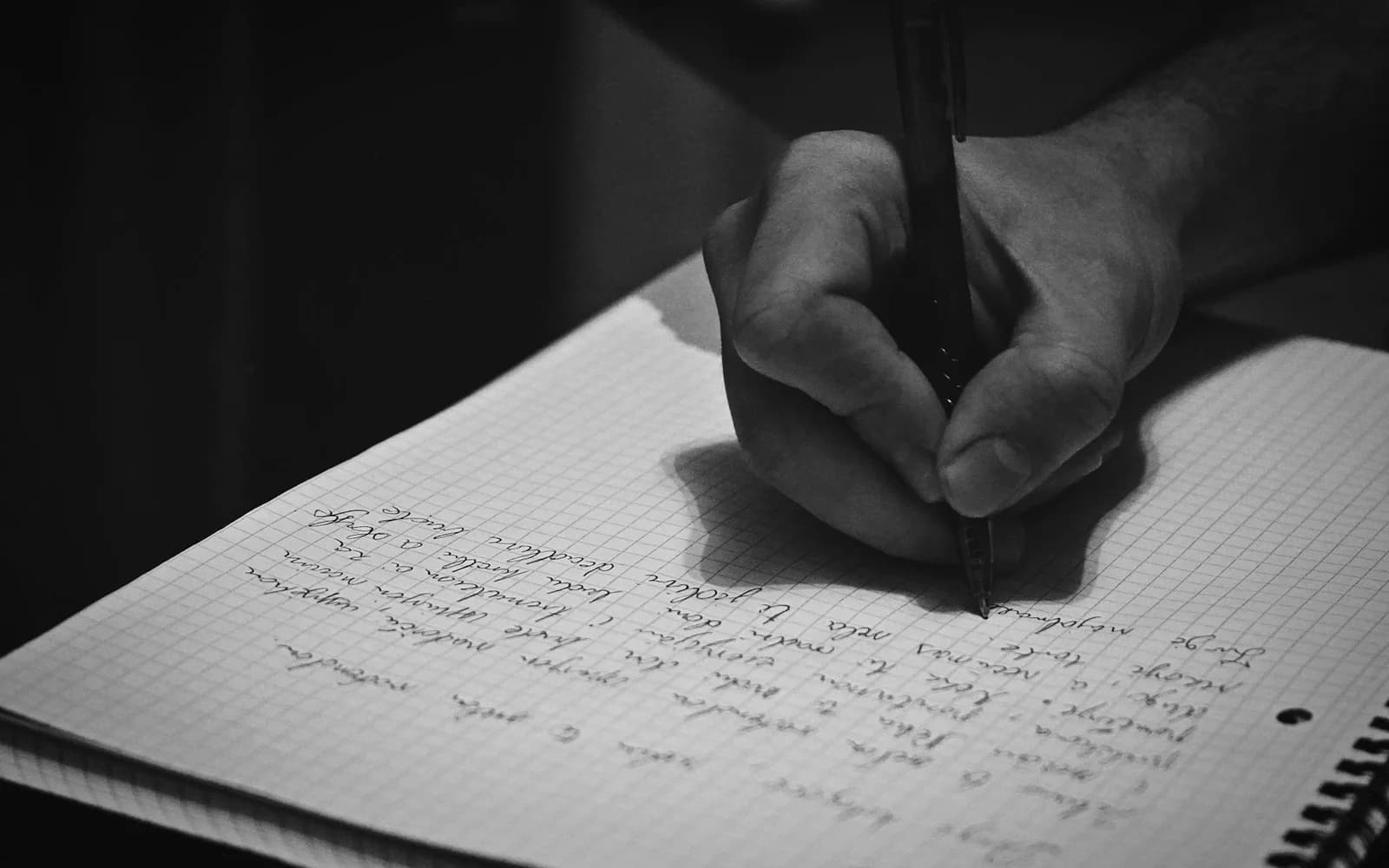 A hand writes a journal entry on lined paper.